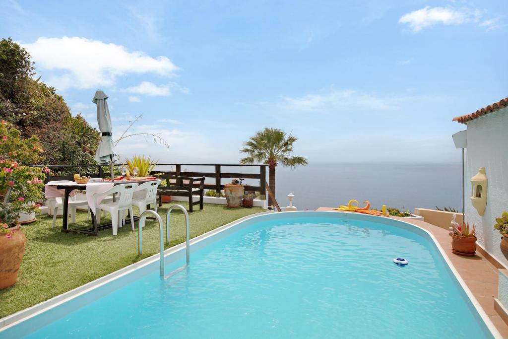 una piscina en un patio con mesa y sillas en Casa Pelican, en Puntillo del Sol