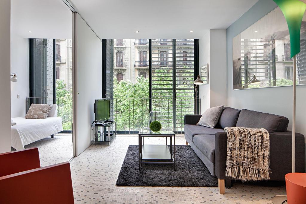 a living room with a couch and a table at Habitat Apartments Pedrera in Barcelona