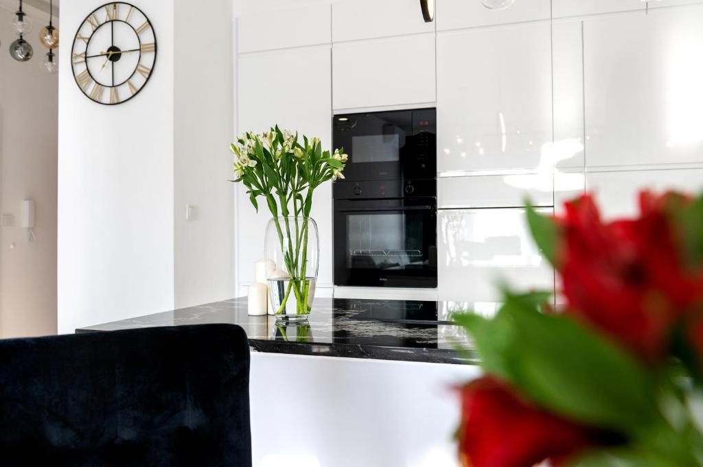 a kitchen with a black counter top with a clock at Silver SPA - 22 in Dziwnów