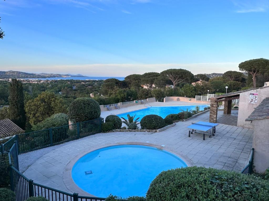 ein großer Pool mit einer Terrasse und einer blauen Bank daneben in der Unterkunft Mazet Bellevue in Cogolin