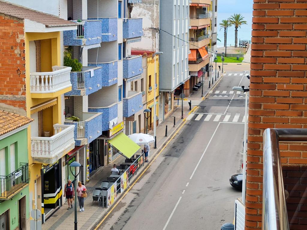 an empty street with blue balconies on a building at Las Jarcias in Moncófar
