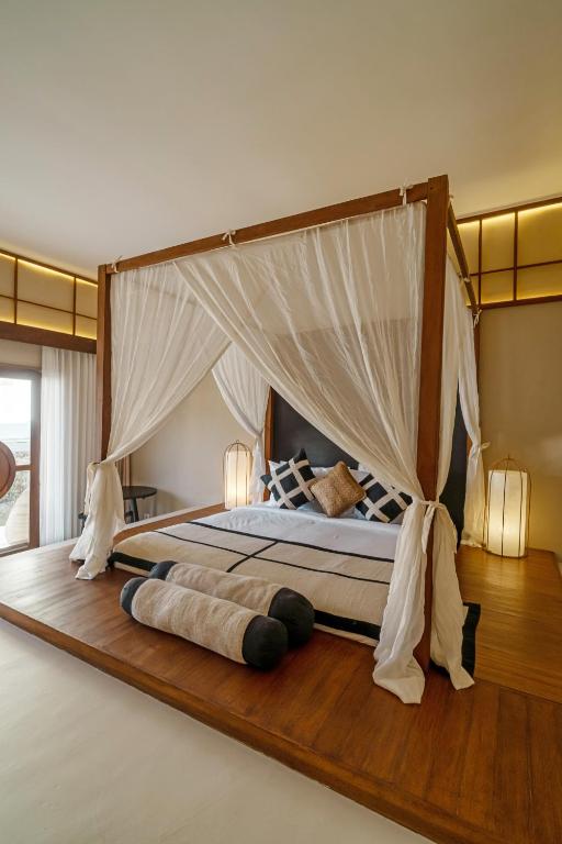un dormitorio con una cama con dosel en IKIGAI Uluwatu Beach, en Uluwatu