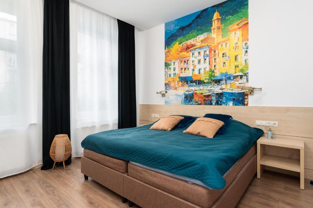 a bedroom with a bed with a painting on the wall at Matejki-Lazurowy in Poznań