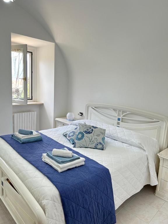 um quarto com uma cama branca e toalhas em La Minicasa em Pacentro