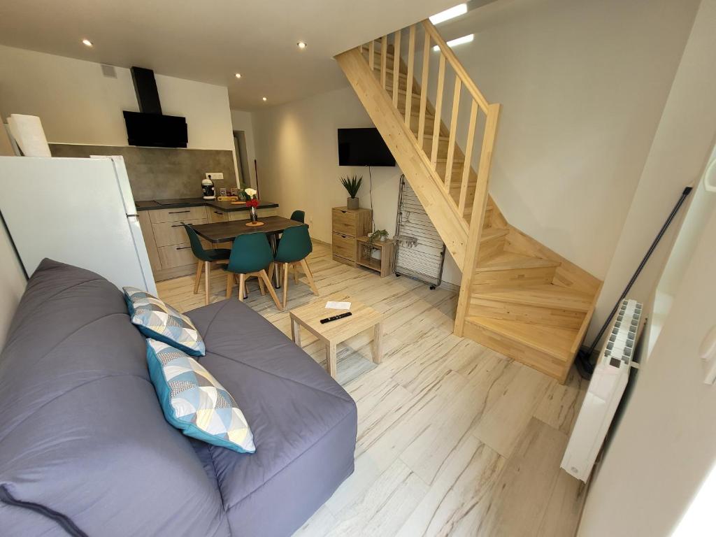 sala de estar con sofá y escalera en Appartement récemment rénové, en Saint-Léger