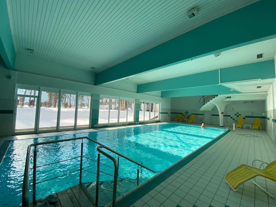a large swimming pool in a large building at Grubhof Studio mit Indoor Pool und Garten in Sankt Martin bei Lofer