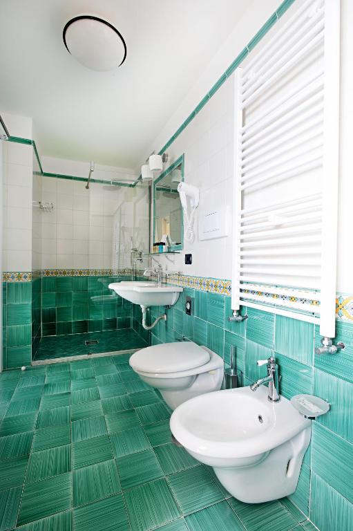 a bathroom with two toilets and two sinks at Hotel Villa Pandora in Maiori