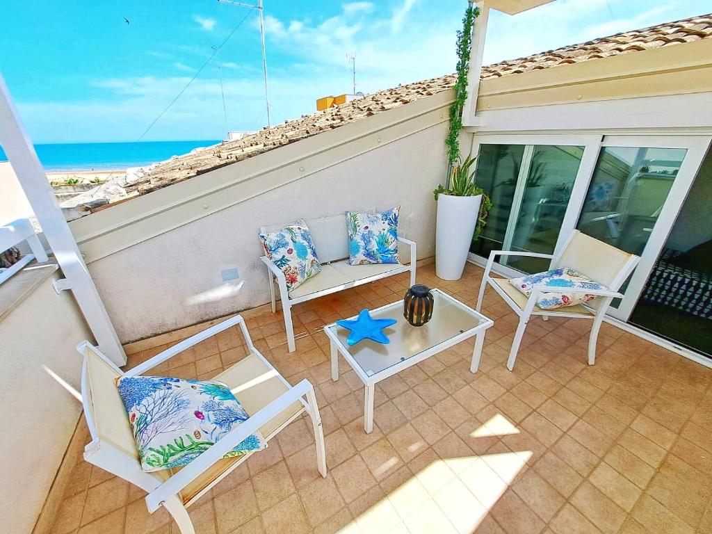 ポッツァッロにあるMare del Sud , Lovely apartment with sea viewのパティオ(椅子、星付きテーブル付)