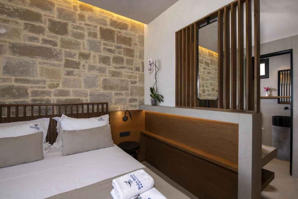 a bedroom with a bed and a stone wall at Balos Beach in Kissamos