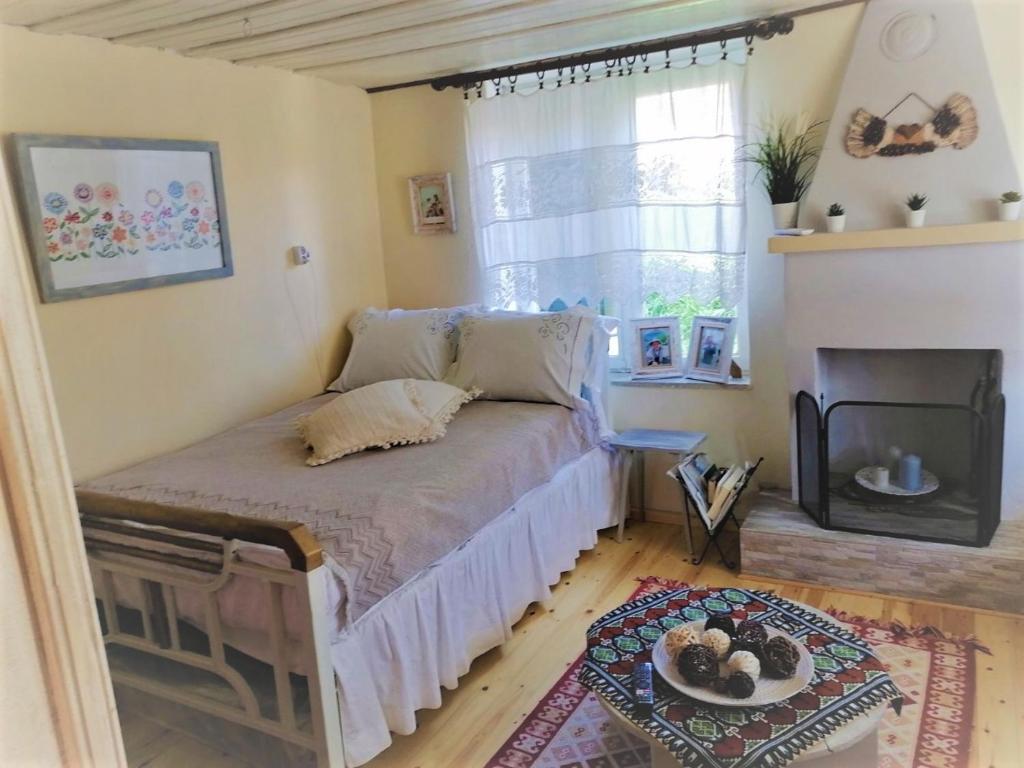 sypialnia z łóżkiem, kominkiem i oknem w obiekcie Maria's traditional house w mieście Tríkeri