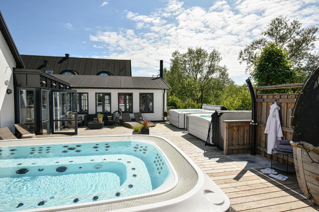 - une piscine sur une terrasse avec une maison dans l'établissement Kåseberga Gårdshotell & Spa, à Kåseberga