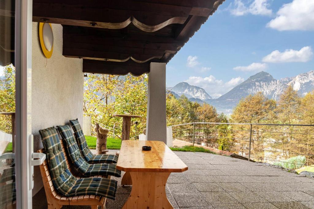 una mesa y 2 sillas en un porche con montañas en Apart Rofan 45m2, en Bruck am Ziller