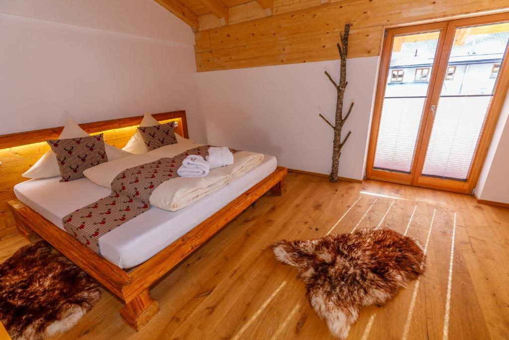 米滕瓦爾德的住宿－Alpenloft 1，卧室配有一张床,地板上放着一只狗