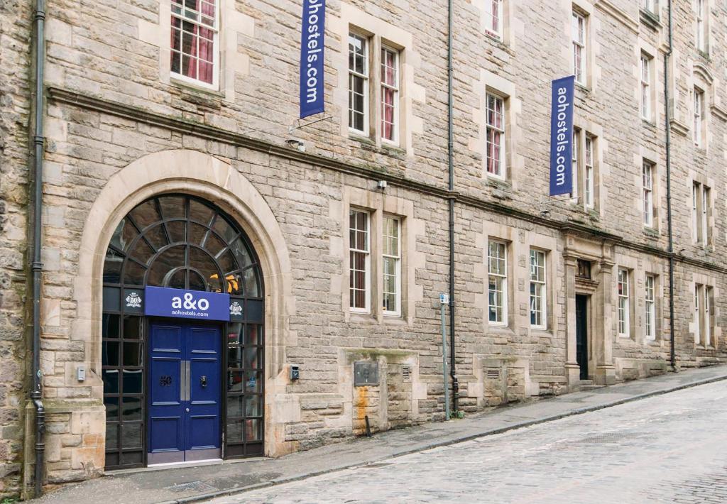 ein Backsteingebäude mit blauer Tür auf einer Straße in der Unterkunft a&o Edinburgh City in Edinburgh