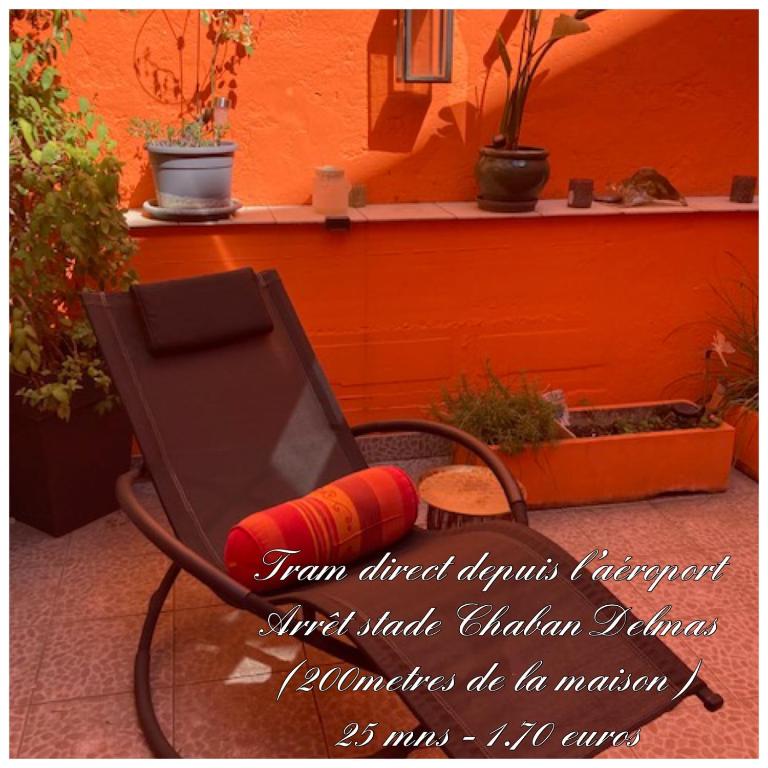 une chaise assise devant un mur orange dans l'établissement Chambre chez l'habitant - proche du centre - salle d'eau et WC privés, à Bordeaux