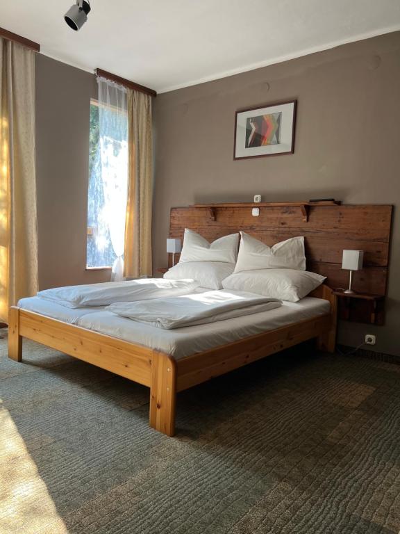 um quarto com uma cama grande e uma cabeceira em madeira em Villa Sagan em Zamárdi