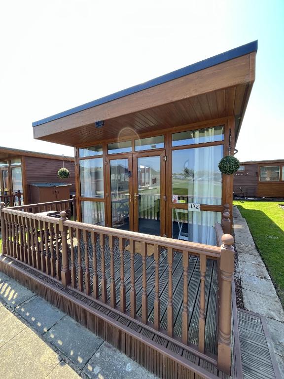 a house with a balcony with glass doors at Cozzzy Seaside Retreat in Mablethorpe