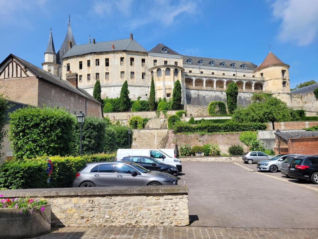 a large building with cars parked in a parking lot at Appartement avec terrasse in Gaillon