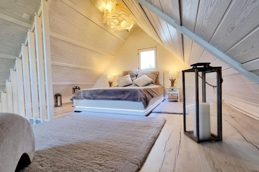 a bedroom with a large bed in a wooden room at O bulles d'Agon Chalet Spa privé Plage in Agon Coutainville