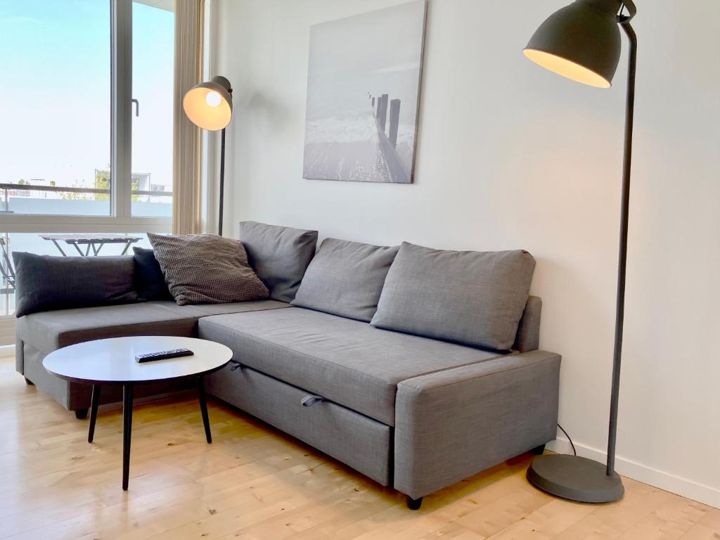 una sala de estar con un sofá y una mesa en Newly Built 1 Bedroom Apartment With Balcony, en Aarhus