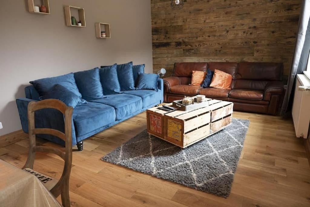 een woonkamer met een blauwe bank en een salontafel bij Gîte de l'Abeille 