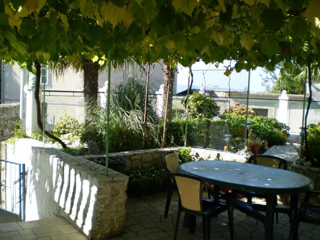 d'une terrasse avec une table et des chaises sous un arbre. dans l'établissement Apartment in Novi Vinodolski with air conditioning, WiFi, washing machine 3541-4, à Novi Vinodolski