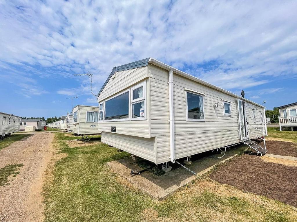 a white tiny house parked in a yard at Lovely 8 Berth Caravan At Manor Park Nearby Hunstanton Beach 23107s in Hunstanton