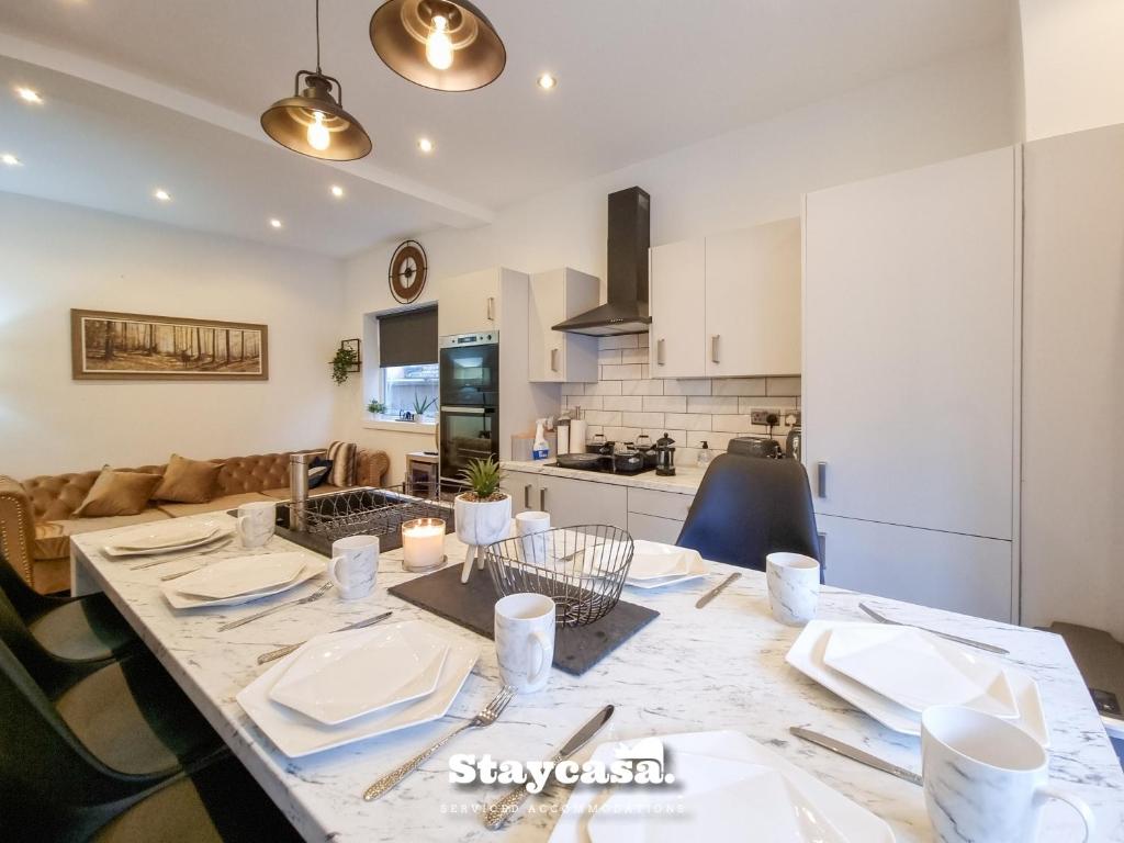 a kitchen and a dining room with a table and chairs at Spacious 6-bed With Large Patio And Free Parking in Manchester