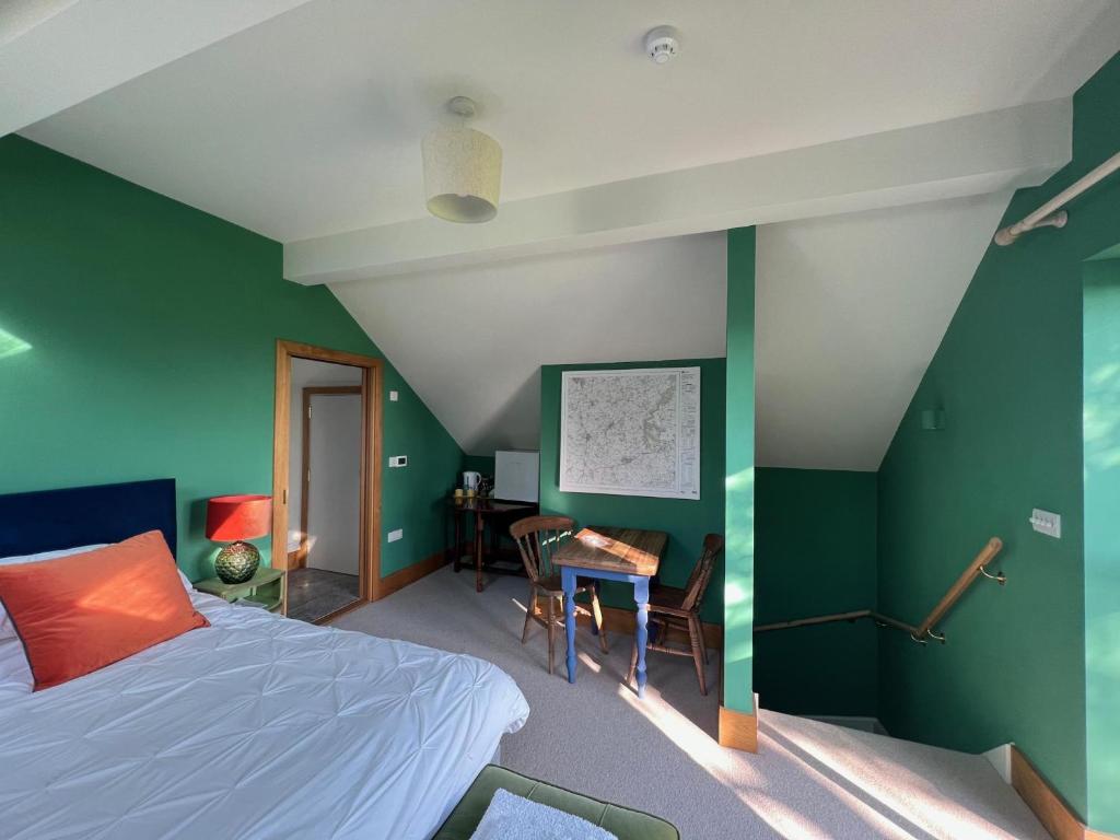 a bedroom with green walls and a bed and a desk at Stunning 1-Bed in Bruton Somerset stunning views in Bruton