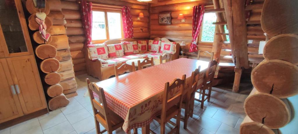 uma sala de jantar com uma mesa e cadeiras num chalé de madeira em La fuste ardennaise em Haybes