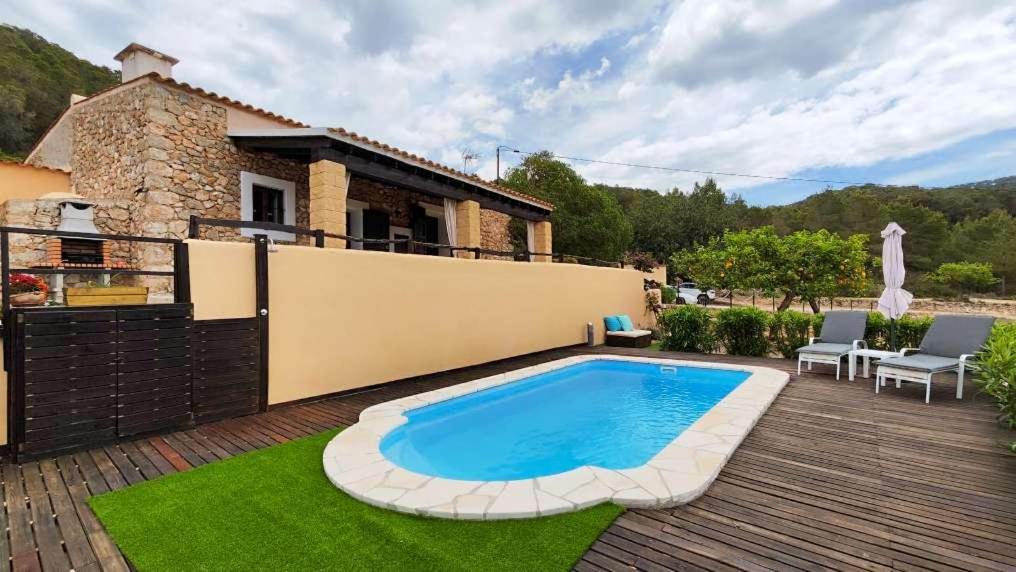 a backyard with a swimming pool and a house at Can Pep de San Plana in Sant Josep de Sa Talaia