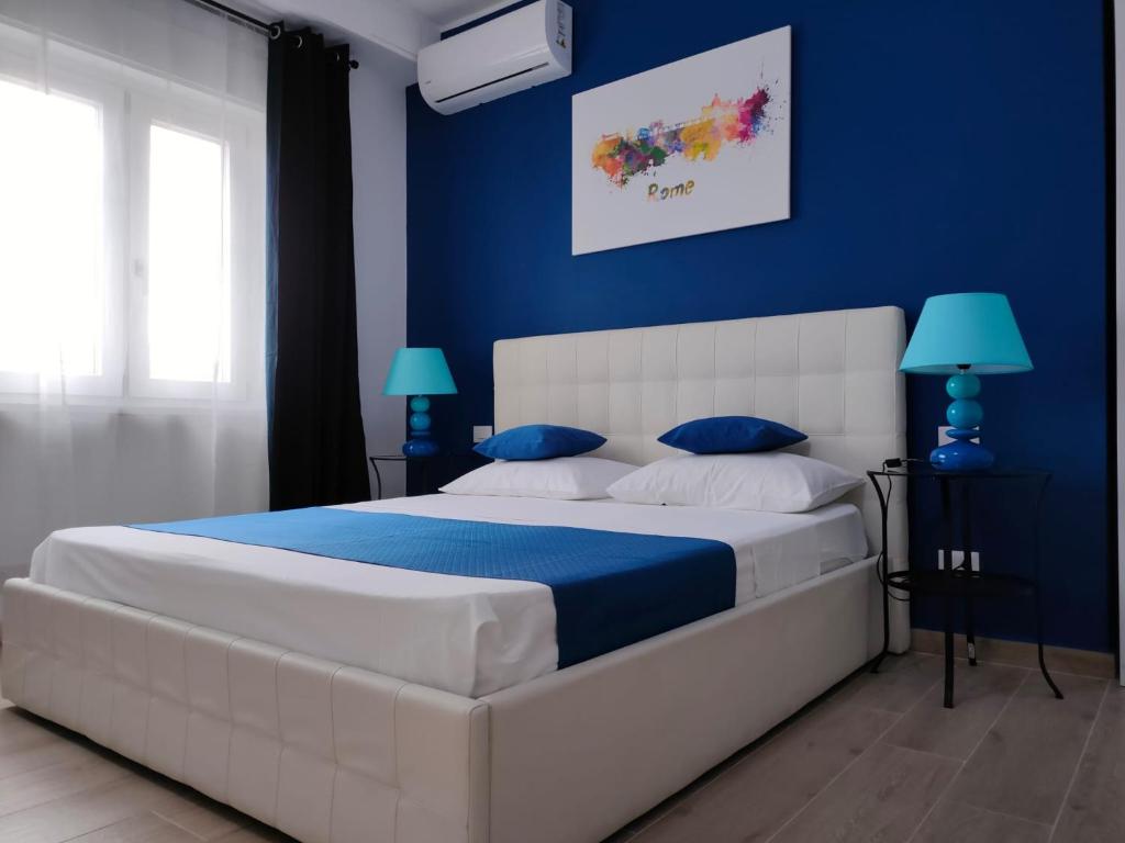 ein Schlafzimmer mit einem großen weißen Bett mit blauen Wänden in der Unterkunft The 6th Floor in Rom