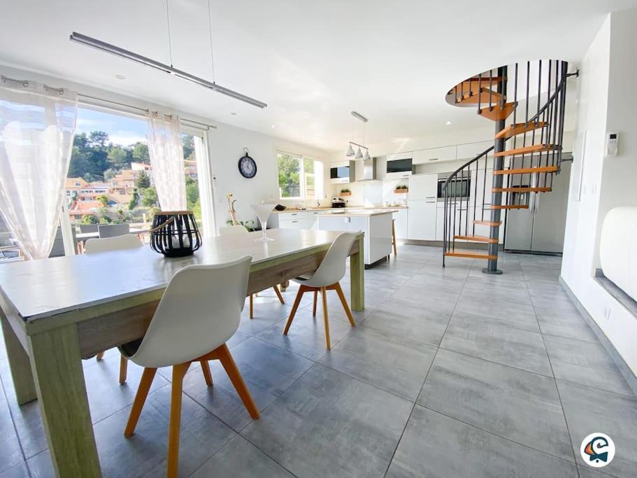 une cuisine et une salle à manger avec une table et des chaises dans l'établissement MAGNIFIQUE VILLA PISCINE PROCHE NICE, à La Trinité