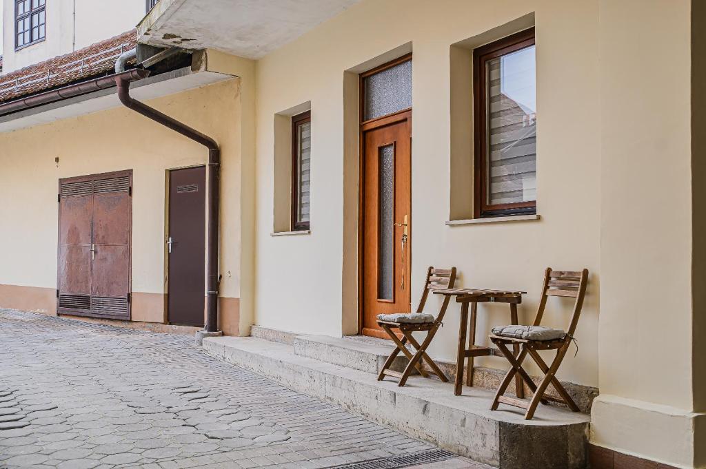 2 chaises et une table à l'extérieur d'un bâtiment dans l'établissement Apartment Trg, à Brežice