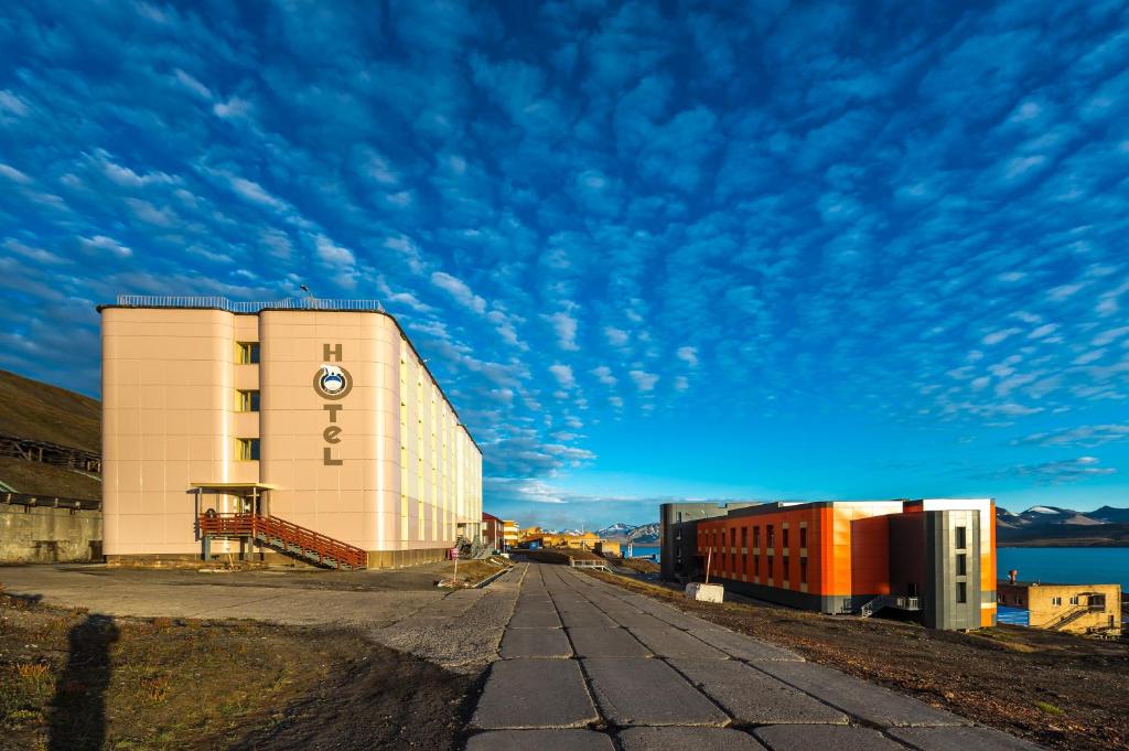 a building on the side of a road next to a train at Hotel Barentsburg in Barentsburg
