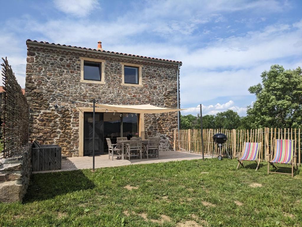 Casa de piedra con patio con sillas y parrilla en La Grange, Gîte 4 à 6 pers avec vue en Saint-Just-près-Brioude