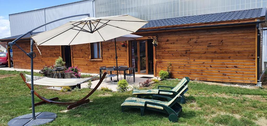 patio con hamaca y sombrilla en Chez LAVALOU Gîte 4* chaleureux en bois, en Lannemezan