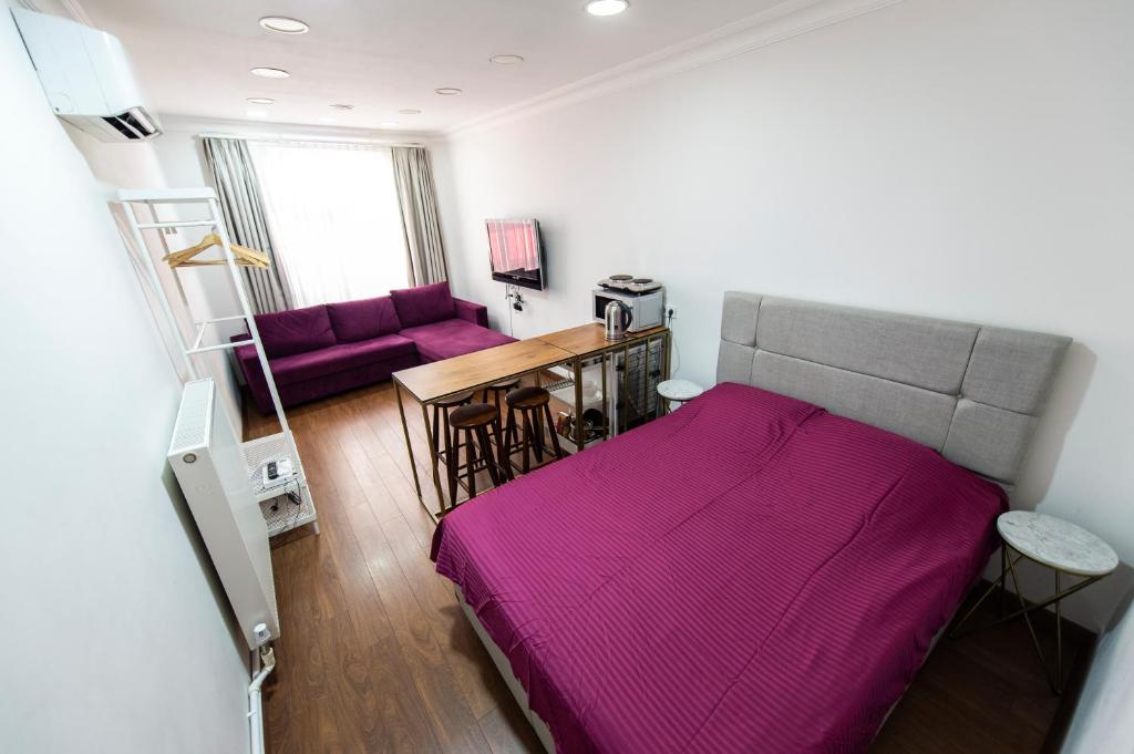ein Schlafzimmer mit einem lila Bett und einem Sofa in der Unterkunft 1st FLOOR STUDIO in TAKSİM NEAR İSTİKLAL STREET in Istanbul