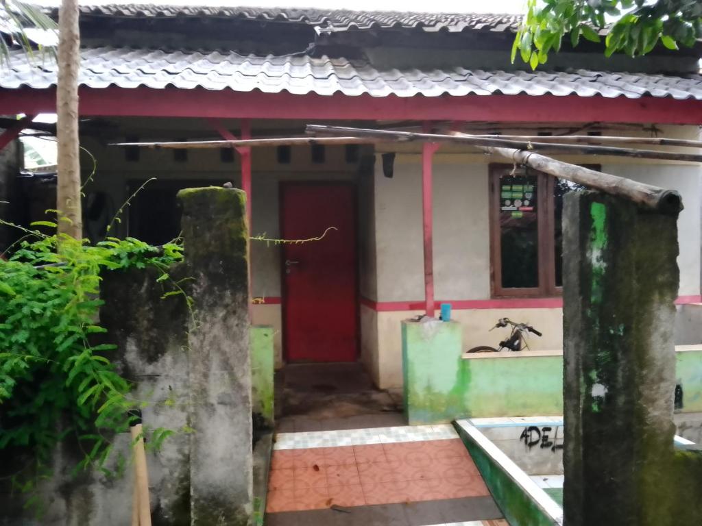 a small house with a red door at Home stay jaya pribadi By 29 
