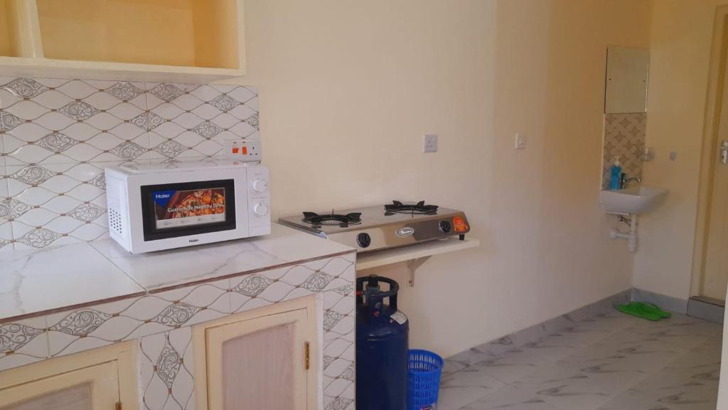 een keuken met een magnetron op een aanrecht bij Crown Apartments in Malindi