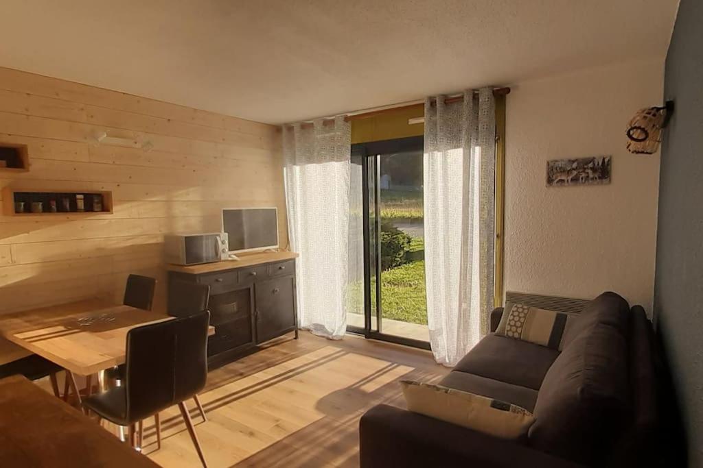 un salon avec un canapé et une table dans l'établissement REZ DE JARDIN CALME ST LARY PROCHE TELECABINE, à Saint-Lary-Soulan