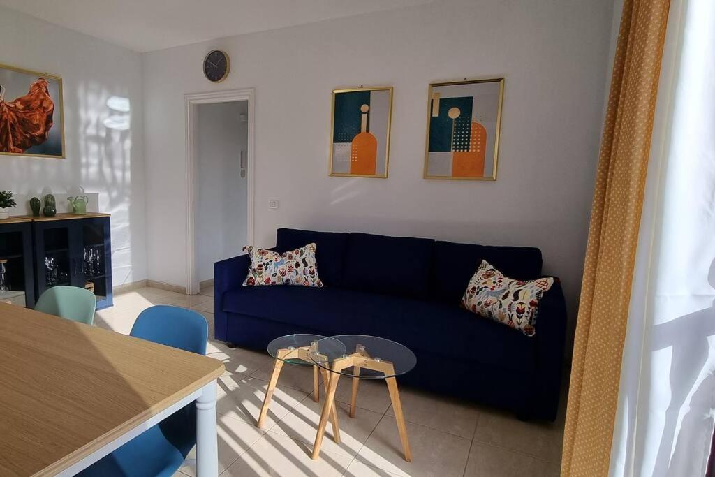 a living room with a blue couch and a table at Appartement calme à 200 m de la mer avec ascenseur in Alcalá