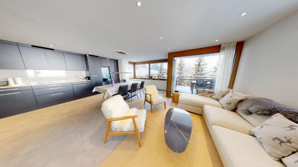 a large living room with white furniture and windows at Alpen-Suite mit Spa & Bergblick in Churwalden