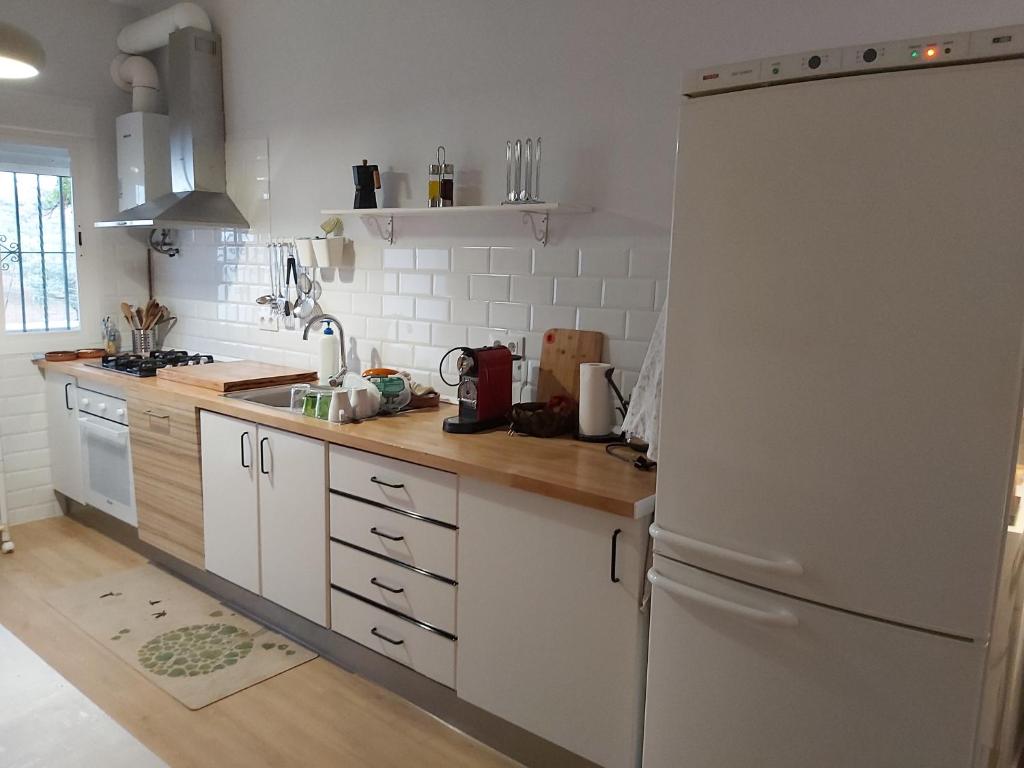 uma cozinha com armários brancos e um frigorífico branco em Casa de la Sierra em Arroyo de la Plata