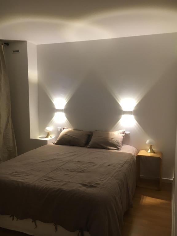 een slaapkamer met een bed met twee verlichting bij REVERIE D'ETE in Vic-Fezensac