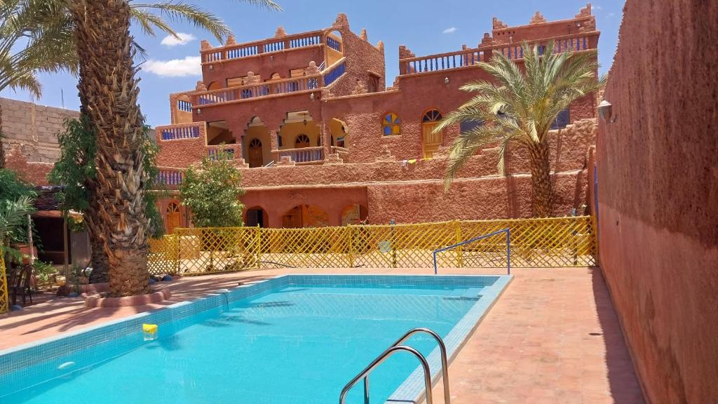 une piscine en face d'un grand bâtiment dans l'établissement Maroc Galacx, à Ouarzazate