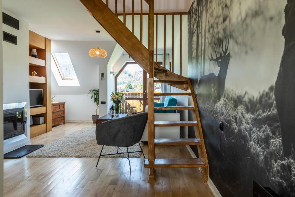 a staircase in a living room with a chair at udanypobyt Apartament Koliba in Kościelisko