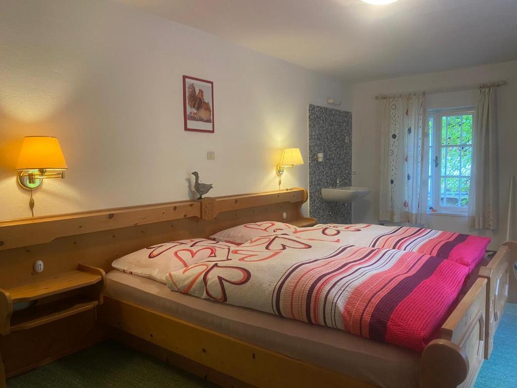 1 dormitorio con 1 cama grande y edredón colorido en Zimmer 3 am Manötscherhof en Tires