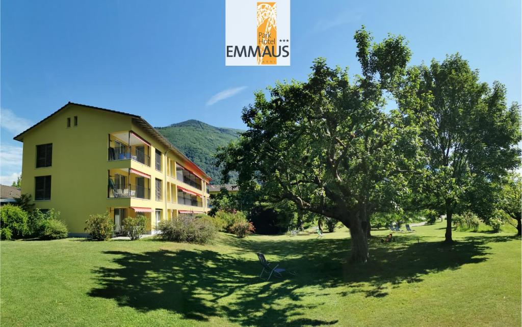 una casa con un árbol delante de ella en Parkhotel Emmaus - Casa del Sole, en Ascona