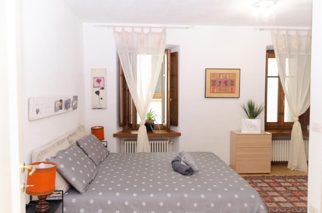 Un dormitorio con una cama y dos ventanas. en Aosta Centro Storico - Les Cretes Apartment Netflix & Relax, en Aosta